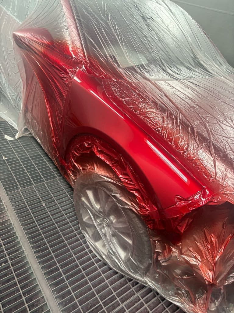 Deep glossy Soul Red paint finish on a Mazda panel