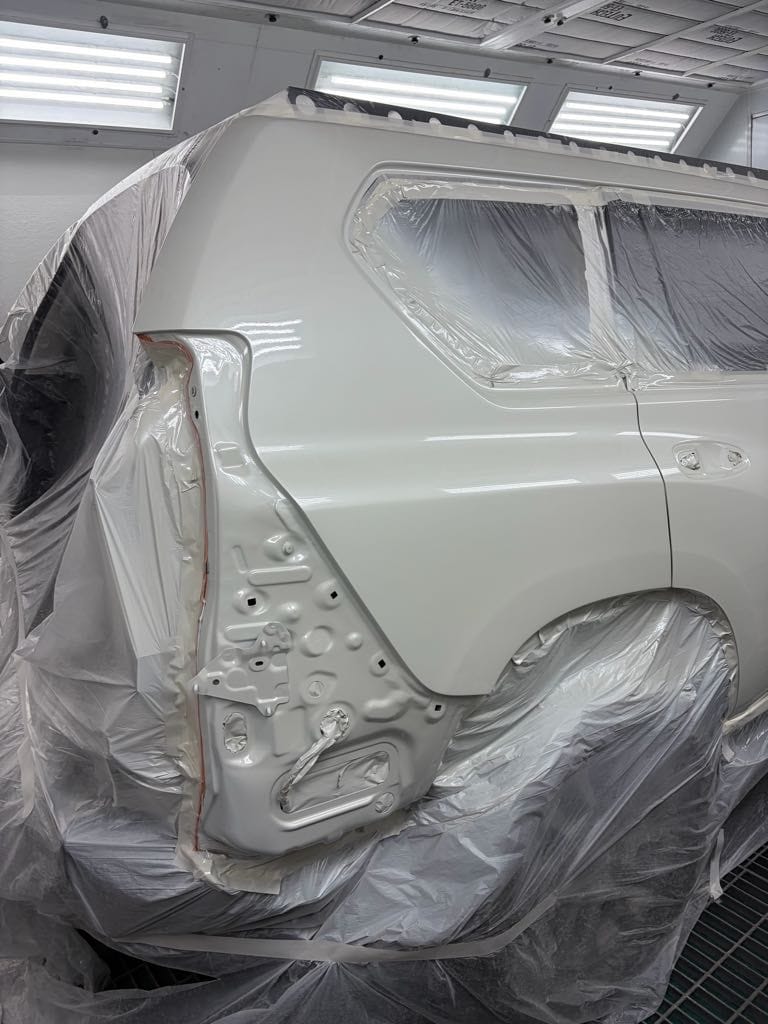 Freshly refinished white Prado panels in the spray booth